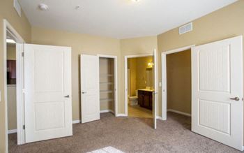 A room with four doors and a carpet on the floor.